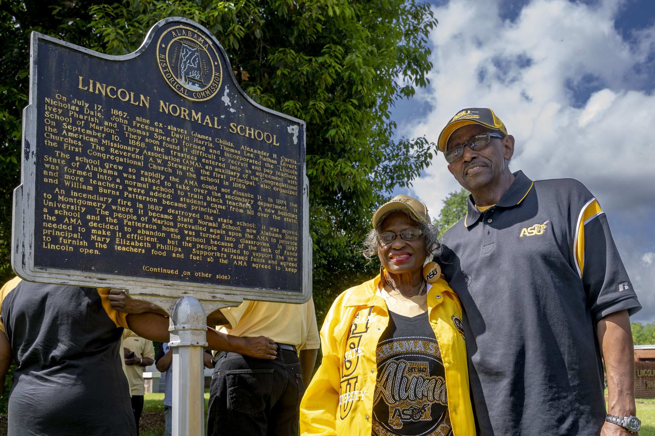 Two ASU alumni stand beside the Lincoln Normal School historical marker in Marion, Alabama.