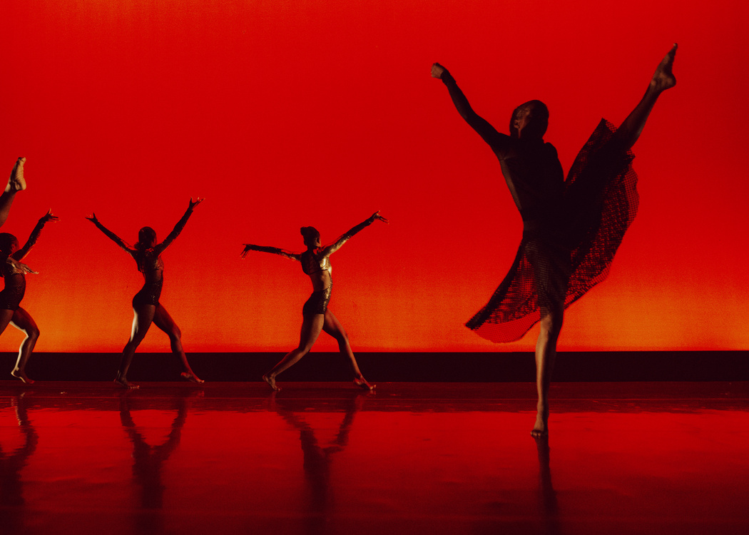 Alabama State Student performers on stage with a red background